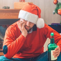 Drunk man sat next to a Christmas tree
