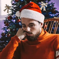 Man sat in a wicker chair looking grumpy