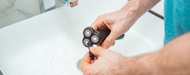 Man Cleaning Rotary Shaver