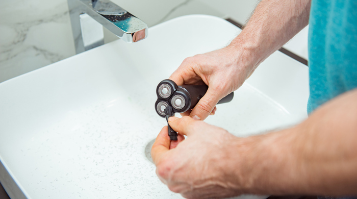 A woman cleaning her electric toothbrush